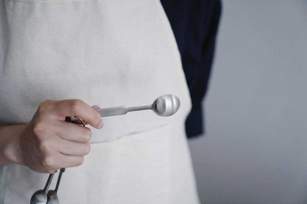 Close-Up Shot of a Person Holding a Measuring Spoon