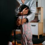 woman in gray cardigan and pink floral dress holding black coated wire