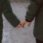 a man and woman holding hands while standing next to each other