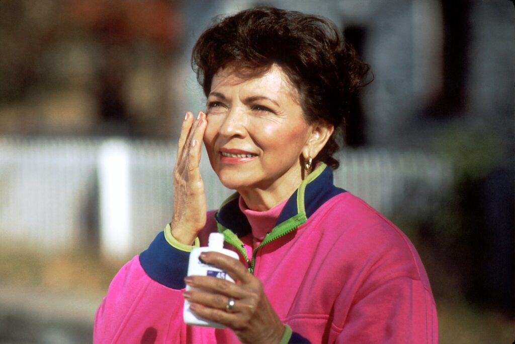 smiling woman in pink and blue shirt